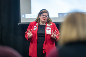 Woman in red jacket giving speech