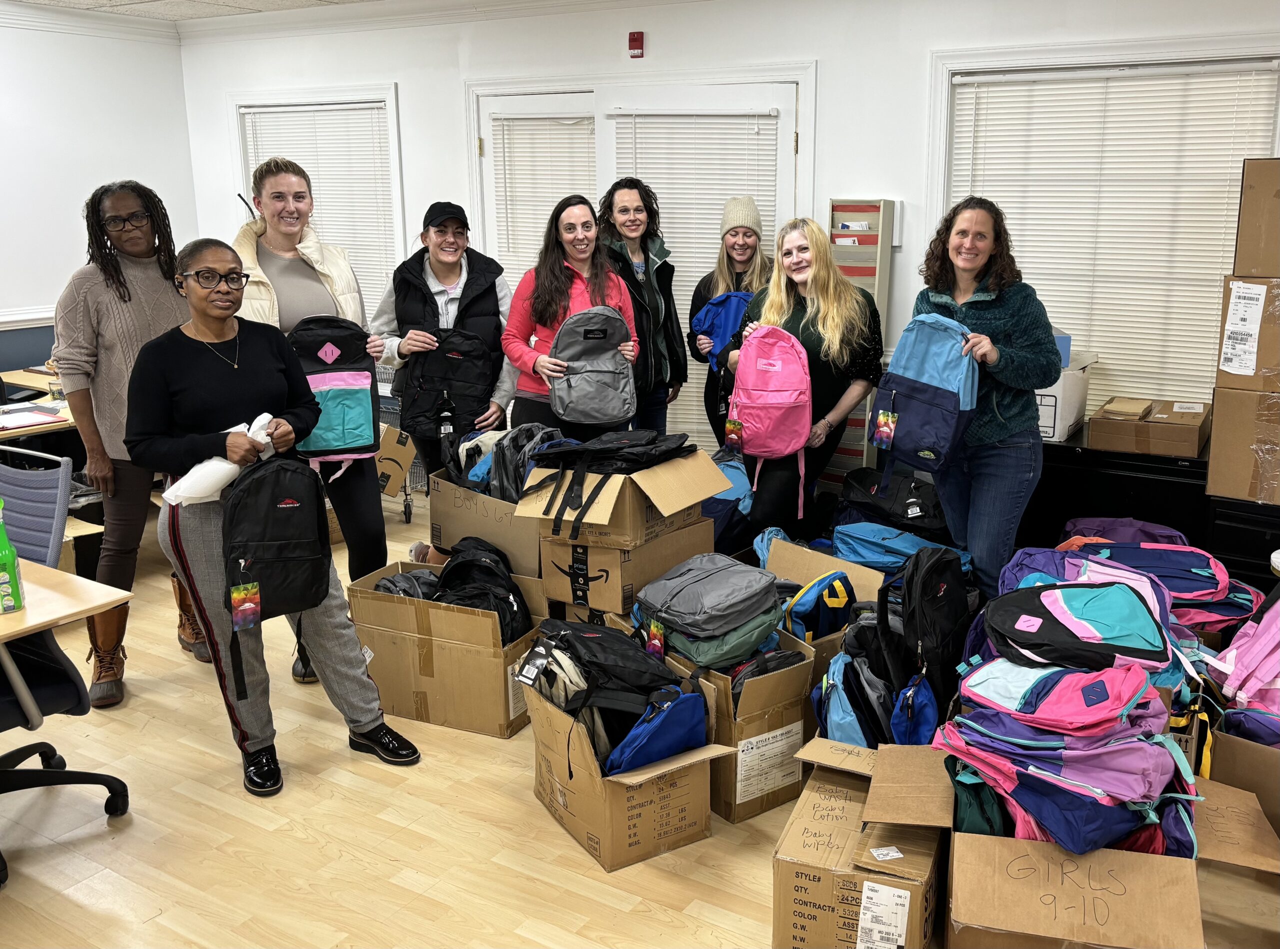 Nine women holding backpacks